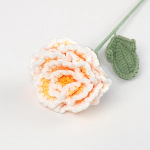 Detail of hand-knitted peony with pink gradient yarn and green stem textures