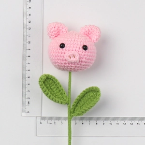 Detailed size view of a handmade pink crochet pig flower bouquet showing 15cm height
