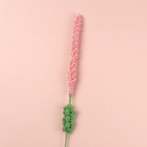 Detail of handmade crochet lavender flower with pink petals and green knitted stem