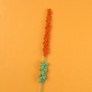 Close-up of handmade crochet lavender flower with detailed orange yarn texture