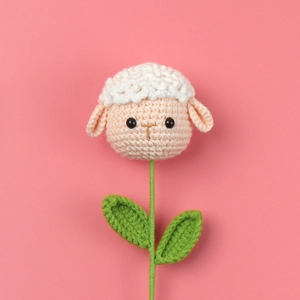 Detail of handmade crochet sheep head flower with green leaves for gift bouquets