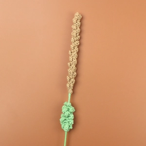 Detailed close-up of handmade crochet lavender flower with beige and green knit patterns