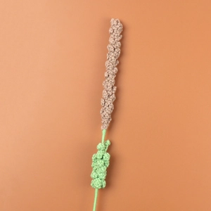 Detailed view of handmade crochet lavender flower featuring textured brown yarn buds