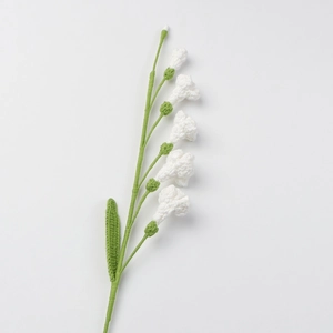 Fleur de freesia faite main au crochet avec pétales blancs et feuilles sur fond blanc