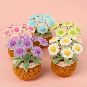 Close-up of five colorful handmade crochet daisy potted plants for desktop decoration
