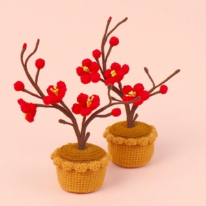 Detail of two handmade crochet plum blossom potted plants with red flowers and brown pots