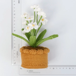 Detaillierte Makroansicht der 18,5 cm hohen handgefertigten Häkelblume im dekorativen Topf