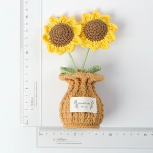 Macro view of handmade crocheted sunflower plant with a Handmade with Love tag and scale ruler