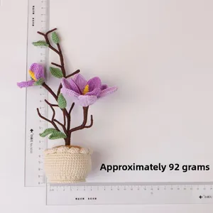 Top view of handmade purple crochet magnolia flower plant in a white pot with rulers