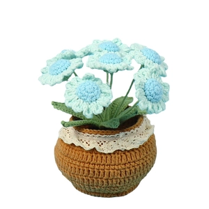 Handmade crochet blue daisy potted plant decoration with brown base and white lace trim