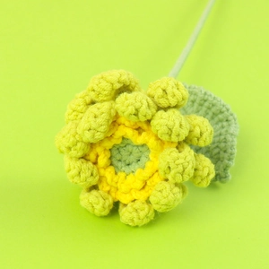 Détail macro d'un tournesol fait main au crochet avec des pétales jaunes et tige verte