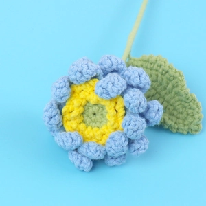 Vue détaillée d'une gerbera faite main au crochet avec texture de tricot bleue