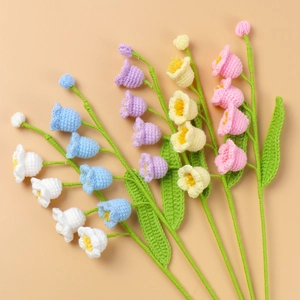 Detailed macro view of colorful handmade crochet Lily of the Valley flowers in five soft tones