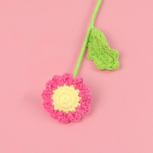 Macro shot of handmade crochet daisy petals with detailed pink and yellow yarn texture