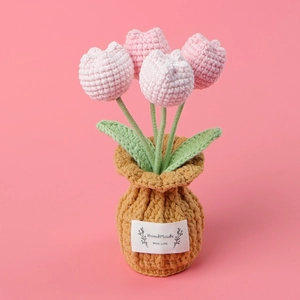Close-up of handmade crochet pink flower pot with a HandMade WITH LOVE fabric label