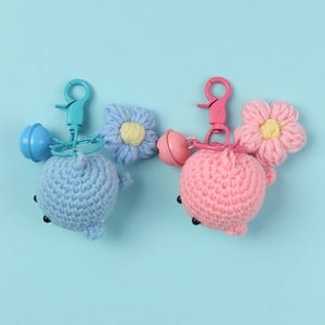 Handmade crochet whale keychains in light blue and pink with floral charm and bell