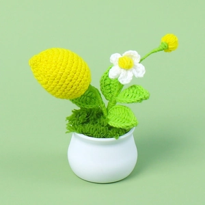 Detailed knit texture of handmade crochet lemon plant in a white ceramic pot