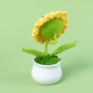 Handgemaakte gehaakte zonnebloem in een witte keramische pot voor tafeldecoratie