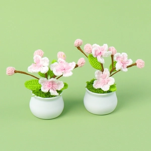 Handmade crochet peach blossom potted plants with pink flowers in white ceramic vases