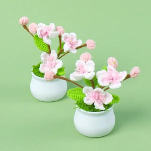 Handmade crochet peach blossom potted plant with pink flowers and white ceramic base