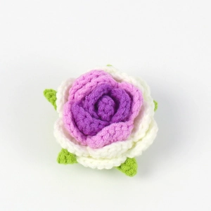 Close-up of handmade crochet rose with gradient purple petals and green knit leaf detail