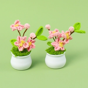 Handmade crochet cherry blossom potted plants with pink flowers in white ceramic pots