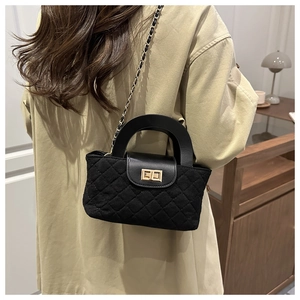 Détail du sac seau noir matelassé avec fermoir doré et bandoulière en chaîne chic