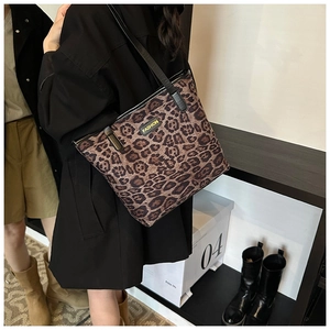 Detail of trendy leopard print tote bag with black fashion tag and slim shoulder straps