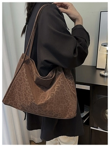 Macro shot of stylish brown leopard print tote bag with soft texture and long shoulder straps