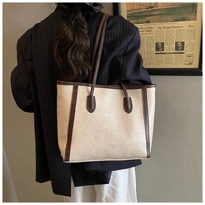 Detailed view of the large vintage tote bag with contrast brown straps on a model