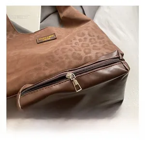 Close-up of leopard print tote bag with premium metal zipper and leather brand label