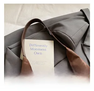 Close-up of the wide comfortable handle on this brown textured leather tote handbag