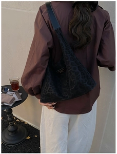 Detail of a large leopard print hobo shoulder bag styled with an autumn outdoor outfit
