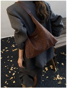 Detailed close-up of dark brown leopard print hobo bag with fashion leather tag