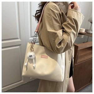 Détail du sac cabas crème avec bandoulière en chaîne rose et charme peluche