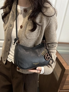 Chic black faux leather crescent hobo bag with unique gold ruler and heart charms