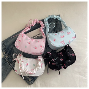 Detailed flat lay of floral print underarm bags with ruffled handles and bow details