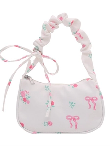 Floral shoulder bag with pink roses, bow prints and ruffled handle on white background