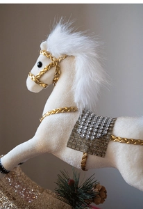 Detailed close-up of white plush Christmas horse ornament with gold sequins and saddle