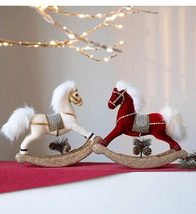 Close-up of red and white velvet rocking horse ornaments with gold glitter base details
