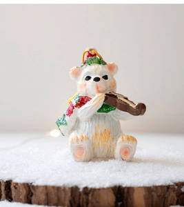 Detail of Christmas polar bear resin figurine playing violin with glitter hat and scarf