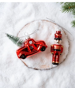 Detailed view of glass Christmas ornaments featuring a red vintage car and nutcracker soldier
