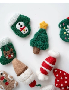 Flache Darstellung von Weihnachts-Wollfilz-Ornamenten mit Schneemann, Rentier und Lebkuchen