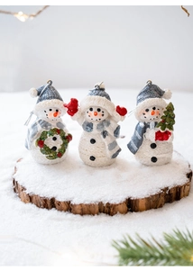 Detailed view of three resin snowmen with knit textures and festive winter scarves