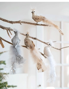 Détail d'oiseaux décoratifs avec paillettes et plumes sur des branches de sapin de Noël