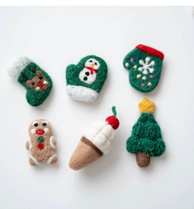 Nahaufnahme von Wollfilz-Weihnachtsanhängern mit Lebkuchenmann und Tannenbaum