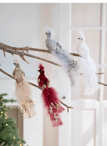 Ornements de paon avec plumes et paillettes exposés sur des branches de Noël