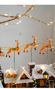 Close-up of flying reindeer over snowy Christmas house with warm glowing LED lights