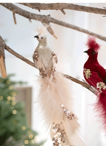 Détail d'oiseaux décoratifs champagne pailleté et rouge velours sur sapin de Noël