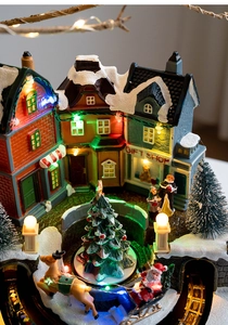 Detail of glowing Christmas gift shop house and rotating tree with LED lighting